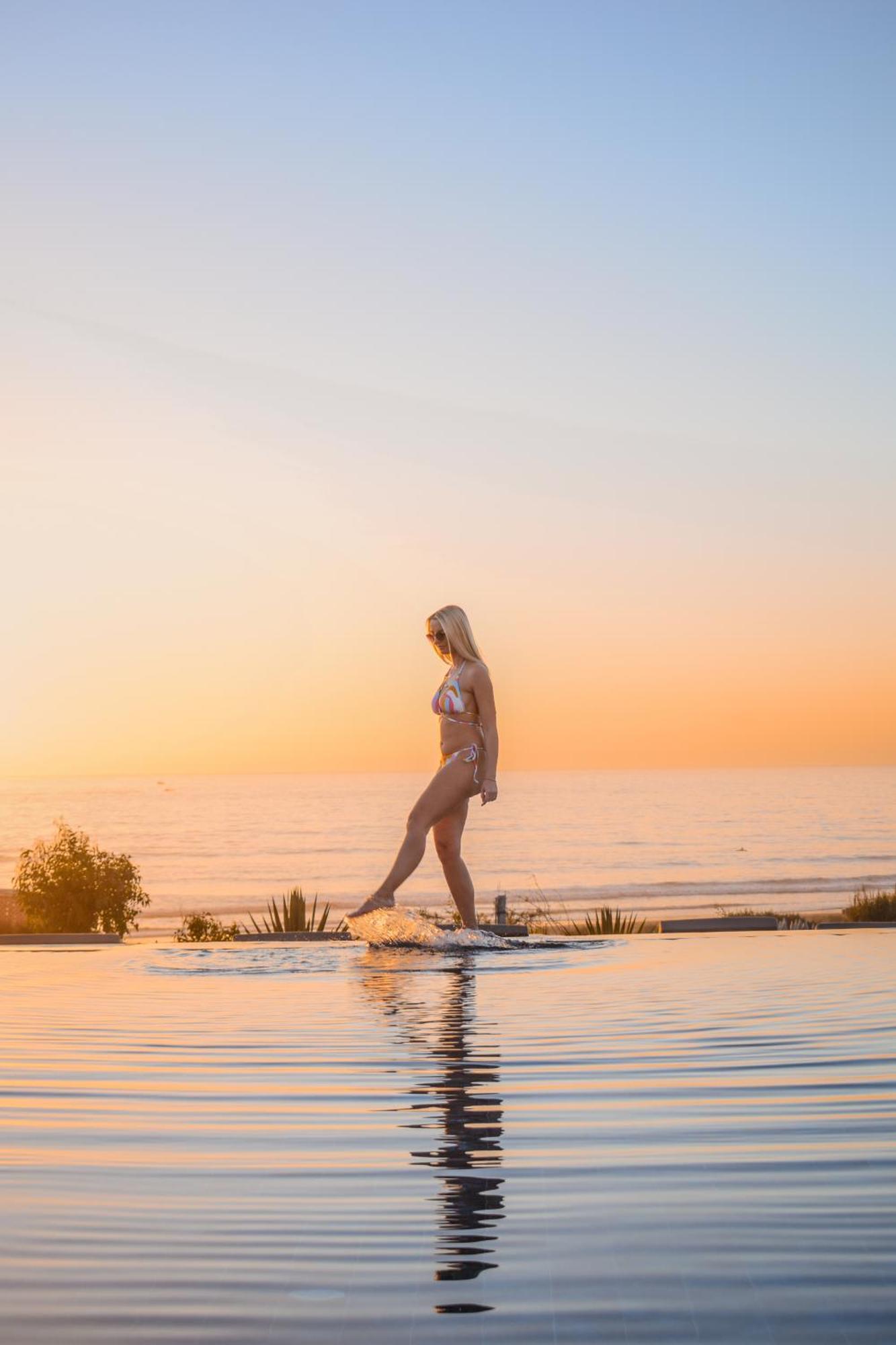 Hyatt Regency Taghazout Exterior foto A woman walking on a skimboard